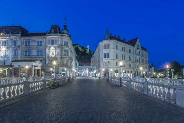 Pedestrian bridge and buildings illuminated at night, Ljubljana, Central Slovenia, Slovenia