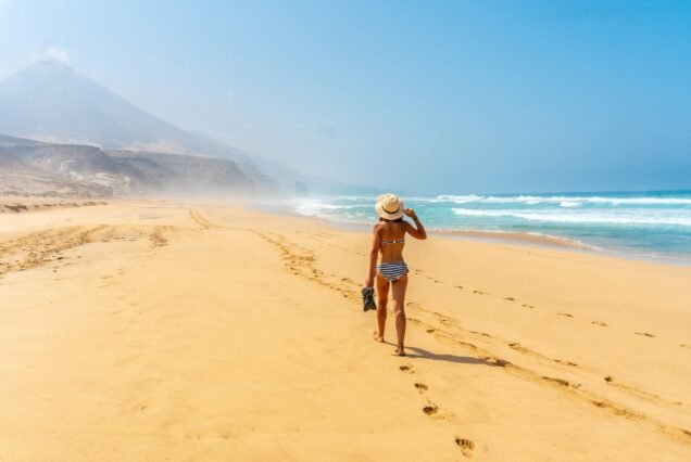 A young woman on the wild beach Cofete of the natural park of Jandia, Fuerteventura