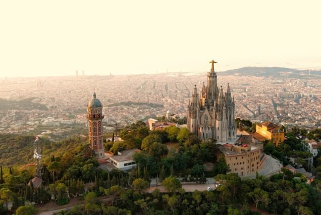 Aerial view of Tibidabo, Barcelona city skyline with Sagrat Cor temple at sunrise. Catalonia, Spain