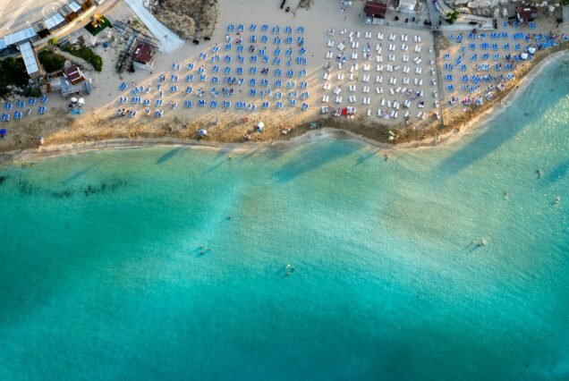 Beach umbrellas in a row at fig tree bay beach Protaras Cyprus. Summer vacations holiday resort