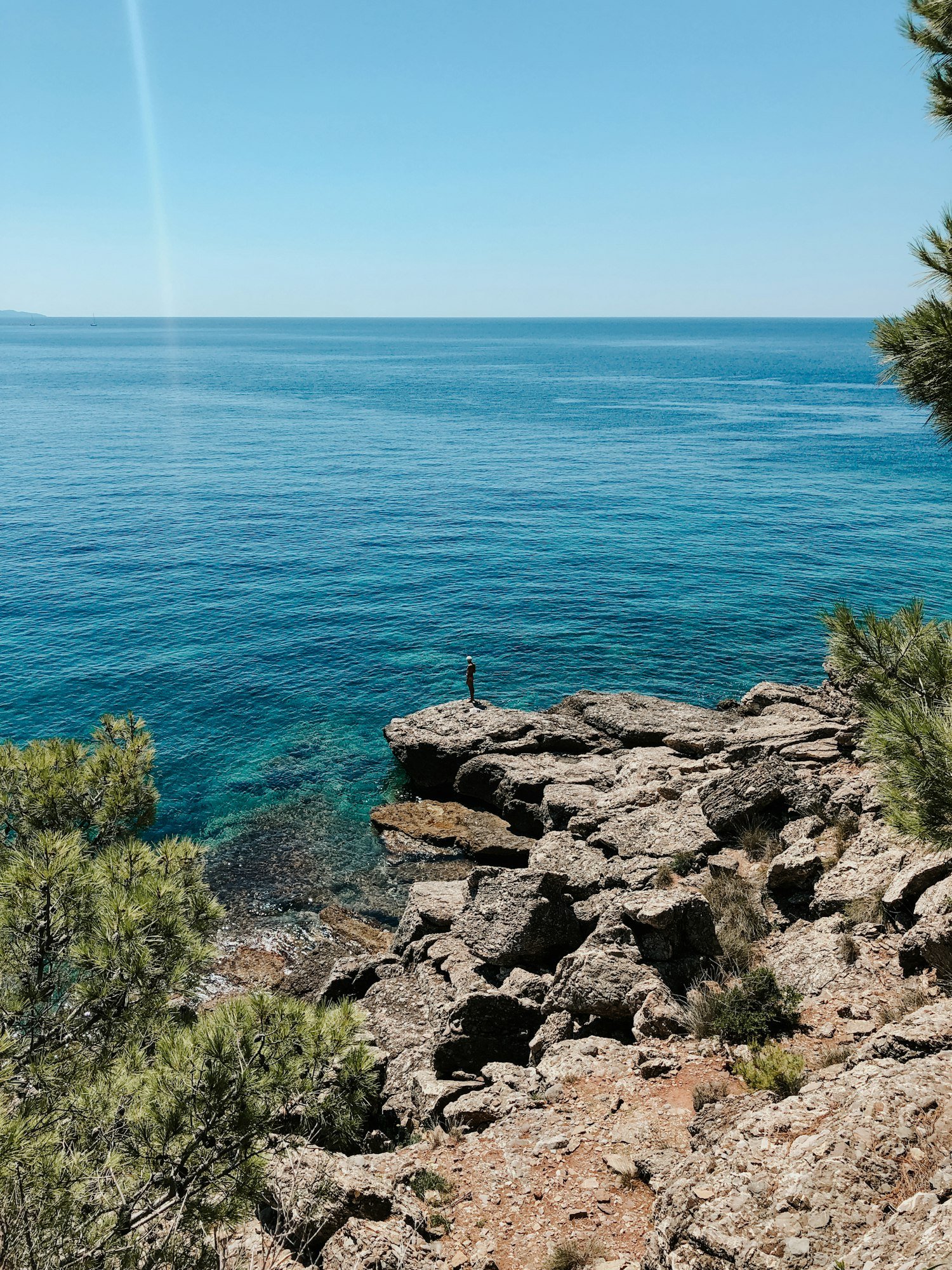 Old man hobby fishing angling standing on big rock stone. senior pensioner catches fish spinning
