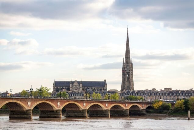 View of St Michel cathedral church in Bordeaux city with a bridge over the river, France