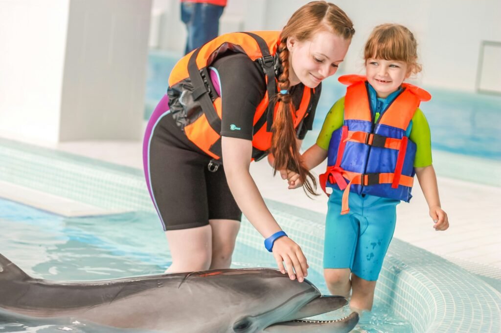 a young woman with her daughter in a dolphinarium swim with dolphins, outdoor activities