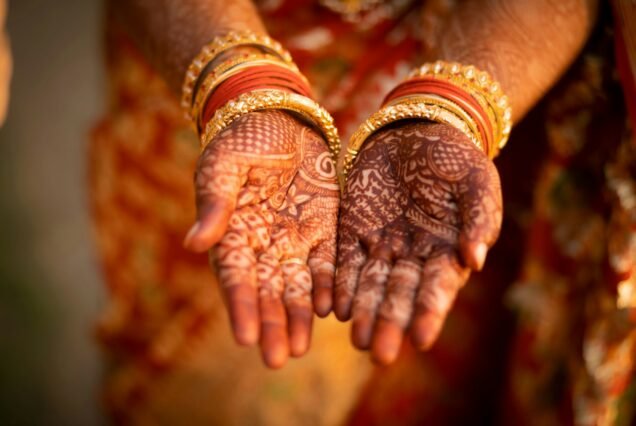 Closeup of a cultural Indian hand henna design on female hands with bracelets