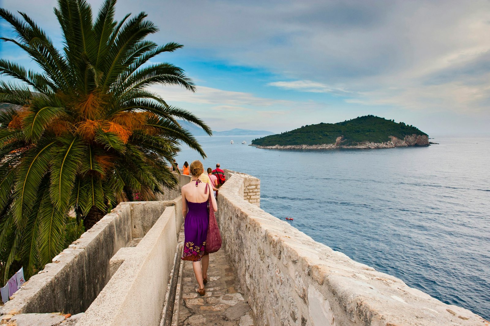 Photo of a tourist walking on Dubrovnik City Walls, Dubrovnik Old Town, Croatia