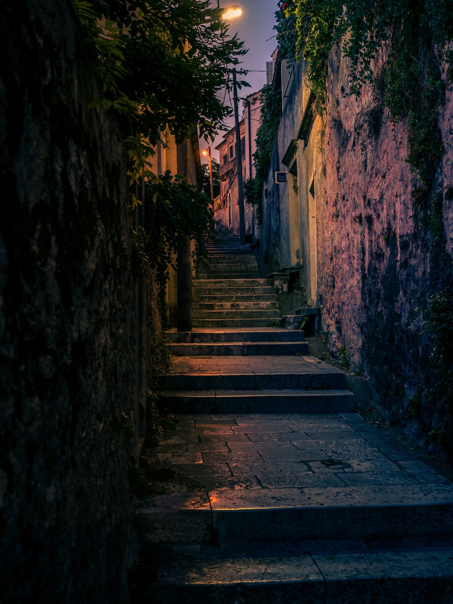 Vertical photo of a narrow alley at night in the city of Dubrovnik